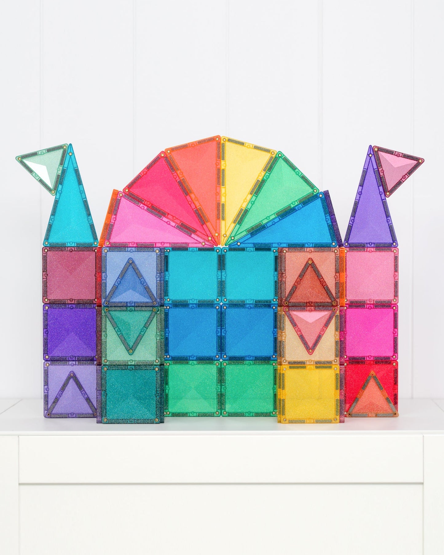 Colorful magnetic building blocks shaped like a castle on a white background