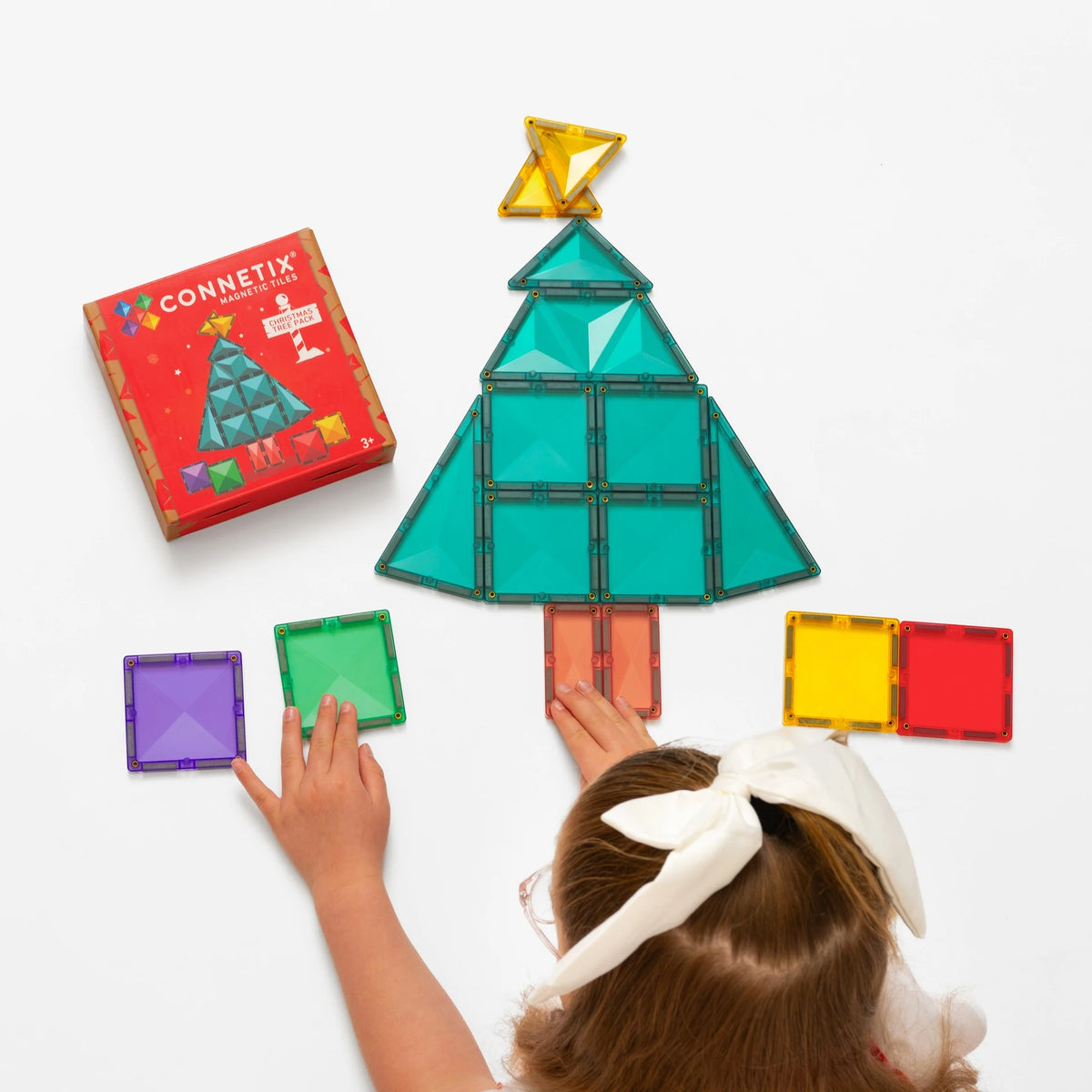 Child building a Christmas tree with Connetix tiles